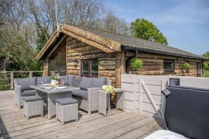 a patio with a table and chairs on a wooden deck at Tesseyman Lodge in Bubwith