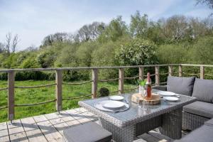 a patio with a table with a bottle of wine at Tesseyman Lodge in Bubwith