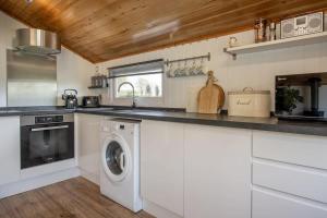 a kitchen with a washer and dryer in it at Tesseyman Lodge in Bubwith +82 photos