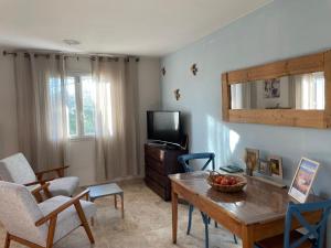 a living room with a table and a tv at ARLES CAMPAGNE LOCATION "La Campagn'Arles" in Arles