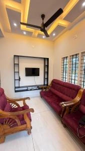a living room with a couch and a flat screen tv at sahara private villa in Cochin