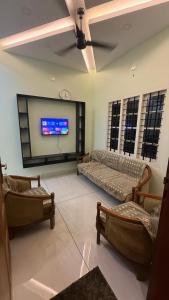 a living room with couches and a flat screen tv at sahara private villa in Cochin