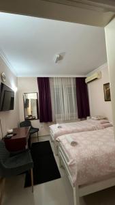 a hotel room with two beds and a desk at Vila Eni in Smederevo