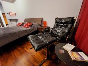 a room with a bed and a chair and a table at Le Cœur Urban Suite Parma in Parma