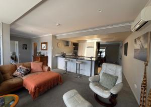 a living room with a couch and a kitchen at Waterfront Retreat on the foreshore of Queen Charlotte Sound in Picton