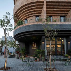 a building with a table and chairs in front of it at Olwen Boutique Hotel in Danang