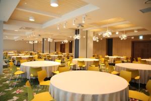 a banquet hall with white tables and yellow chairs at Hotelaround Forest in Pyeongchang