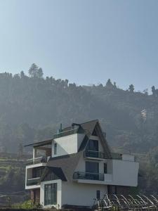 a white building with a black roof at Calmsutra retreat in Sānkhu