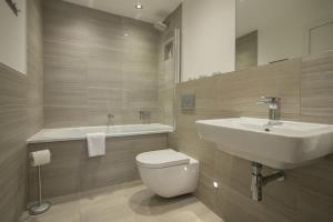 a bathroom with a sink and a toilet and a tub at ChocoLets - The Lion Suite in York