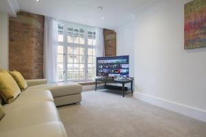 a living room with a couch and a tv at ChocoLets - The Lion Suite in York