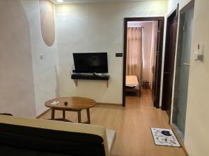 a living room with a couch and a tv and a table at Casanova Penuin Batam in Nagoya