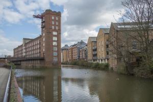 a river in a city with buildings and a tower at ChocoLets - The Lion Suite in York