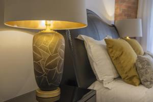 a lamp sitting on a table next to a bed at ChocoLets - The Lion Suite in York +44 photos