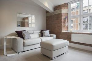 a living room with a white couch and a stool at ChocoLets - The Quality Suite in York