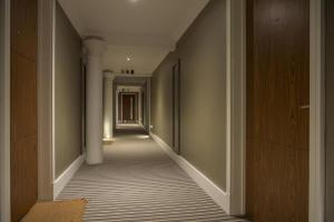 an empty hallway with white columns and a long corridor at ChocoLets - The Quality Suite in York +39 photos