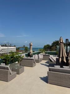 a row of wicker chairs and umbrellas on a patio at Hostel Samui in Nathon Bay