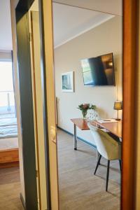 a room with a desk and a bedroom with a bed at Hotel Viva Bröckel in Bröckel