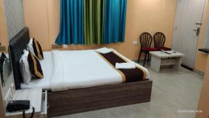 a bedroom with a bed and a table and chairs at Hotel Tara Darshan in Tarapith