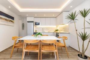 a kitchen and dining room with a white table and chairs at Monte Tulum in Torrent