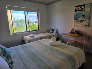 a small bedroom with two beds and a window at CHILL-OUT BEACHSIDE - Main Beach Forster in Forster