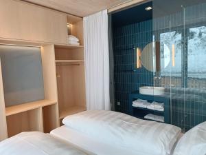 a bathroom with a bed and a sink and a mirror at Jules - Come Together in Stuben am Arlberg