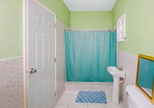 a bathroom with a blue shower curtain and a toilet at Scarlett Near Cane River Falls in Bull Bay +22 photos