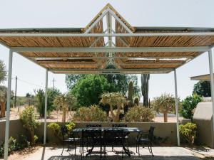 a patio with a table and chairs under a pergola at Kokerboom House in Vanrhynsdorp +10 photos