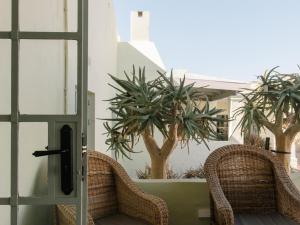 two wicker chairs sitting in front of a door at Kokerboom House in Vanrhynsdorp