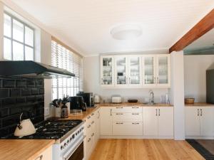 a kitchen with white cabinets and a stove top oven at Kokerboom House in Vanrhynsdorp