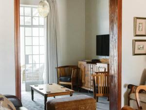 a living room with a table and a couch and a tv at Kokerboom House in Vanrhynsdorp
