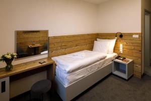 a small bedroom with a bed with a mirror at Sporthotel Olympia in Stachy +27 photos