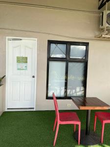 a table and two red chairs in front of a door at Serenity Busay Room 5 in Cebu City