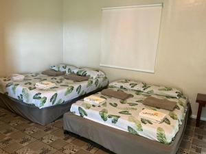 two beds sitting next to each other in a room at Serenity Busay Room 5 in Cebu City