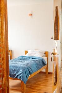 a bedroom with a bed with a blue blanket at Ethico Retreat Formely Five14 BnB in Pātan +5 photos