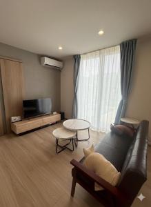 a living room with a couch and a tv at 熊本Station one in Kumamoto