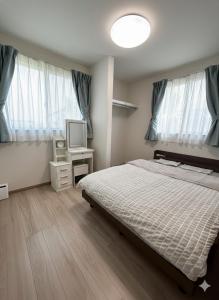 a bedroom with a bed and a tv in it at 熊本Station one in Kumamoto