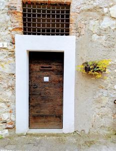 a wooden door in a stone building with a window at Corte del Cedro in Provaglio d'Iseo