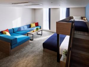 a hotel room with a bed and a couch at Minn STATION Ai Nagoya in Aoichō