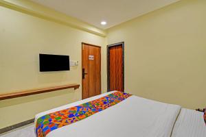 a bedroom with a bed with a colorful blanket on it at FabHotel SRP in Hyderabad