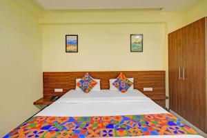 a bedroom with a large bed with a colorful comforter at FabHotel SRP in Hyderabad +24 photos