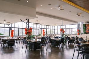 a dining room with tables and chairs and large windows at Serenity Busay Room 3 in Cebu City