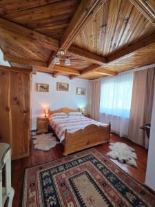 a bedroom with a bed and a wooden ceiling at Casa DelCris in Pojorâta +21 photos