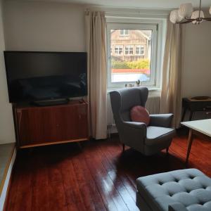 a living room with a chair and a television at Himmel in Ebensee