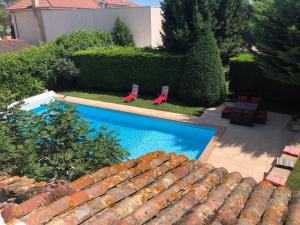 an overhead view of a swimming pool with two chairs at Les Loges de Bacchus in Chonas-lʼAmballan +18 photos