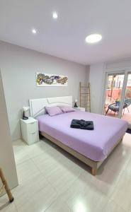 a bedroom with a large bed with a purple blanket at Citadel Oliva 4p Roses, Beach & Centre, Private Parking, Terrace in Roses