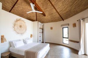 a bedroom with a bed and a ceiling fan at Adouna Bay in Cap Skirring