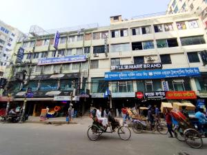 a group of people riding bikes on a city street at Hotel Taqwa Dhanmondi in Dhaka