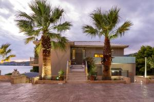 a house with two palm trees in front of it at Core Luxury Suites in Skiathos