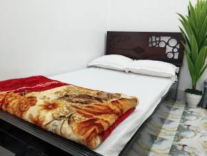 a bedroom with a bed with white sheets at Hotel Taqwa Dhanmondi in Dhaka