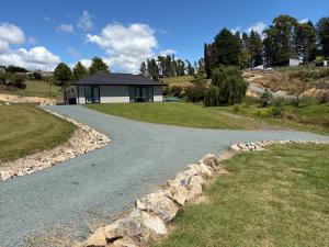 a gravel road leading to a house with a building at The Cottage at 105 in Redwoods Valley